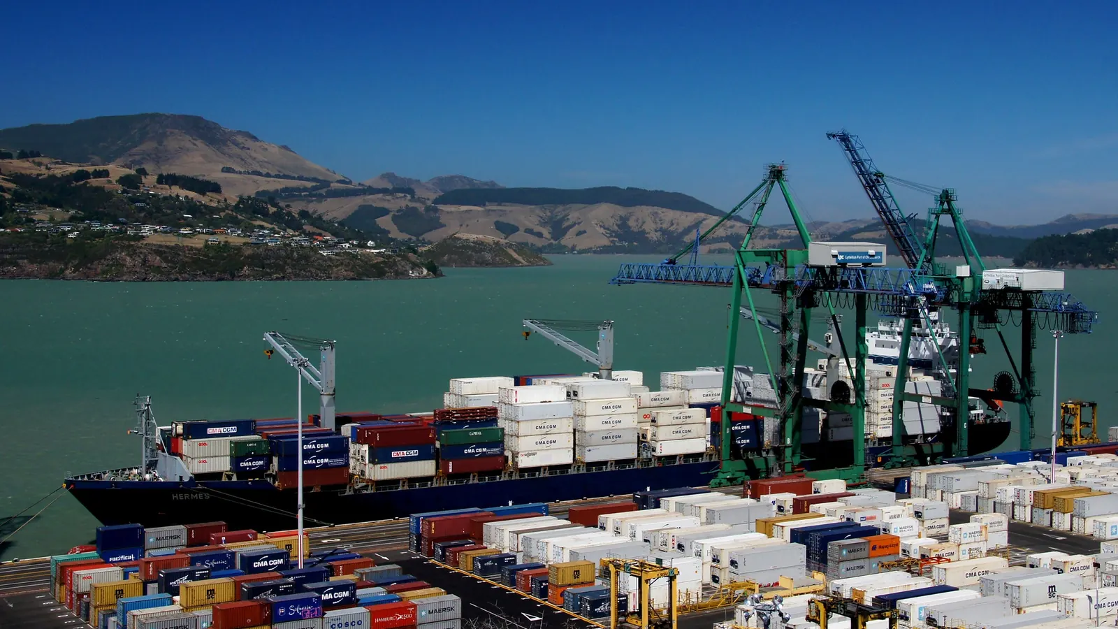 Container cranes and stacked shipping containers at a busy port