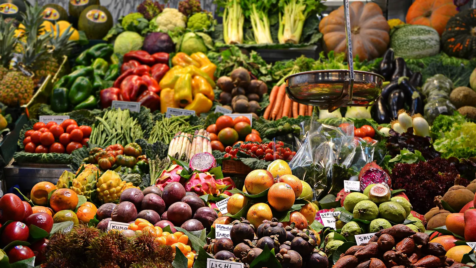 A busy market stall piled with fresh fruit and vegetables