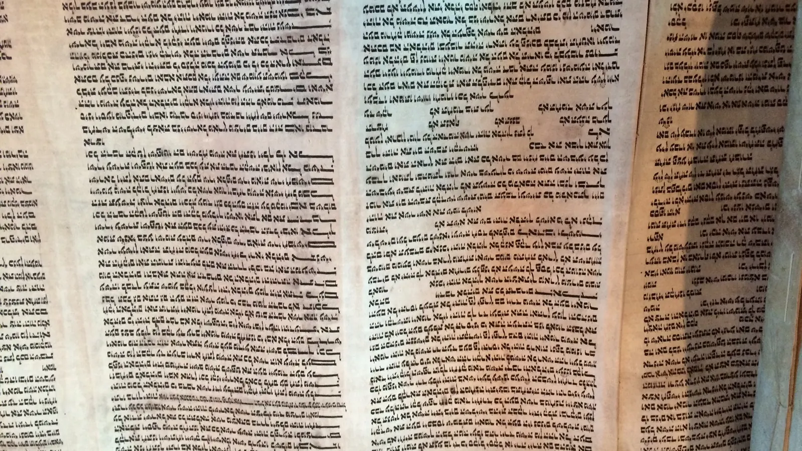 Close-up of handwritten Hebrew letters on a parchment scroll