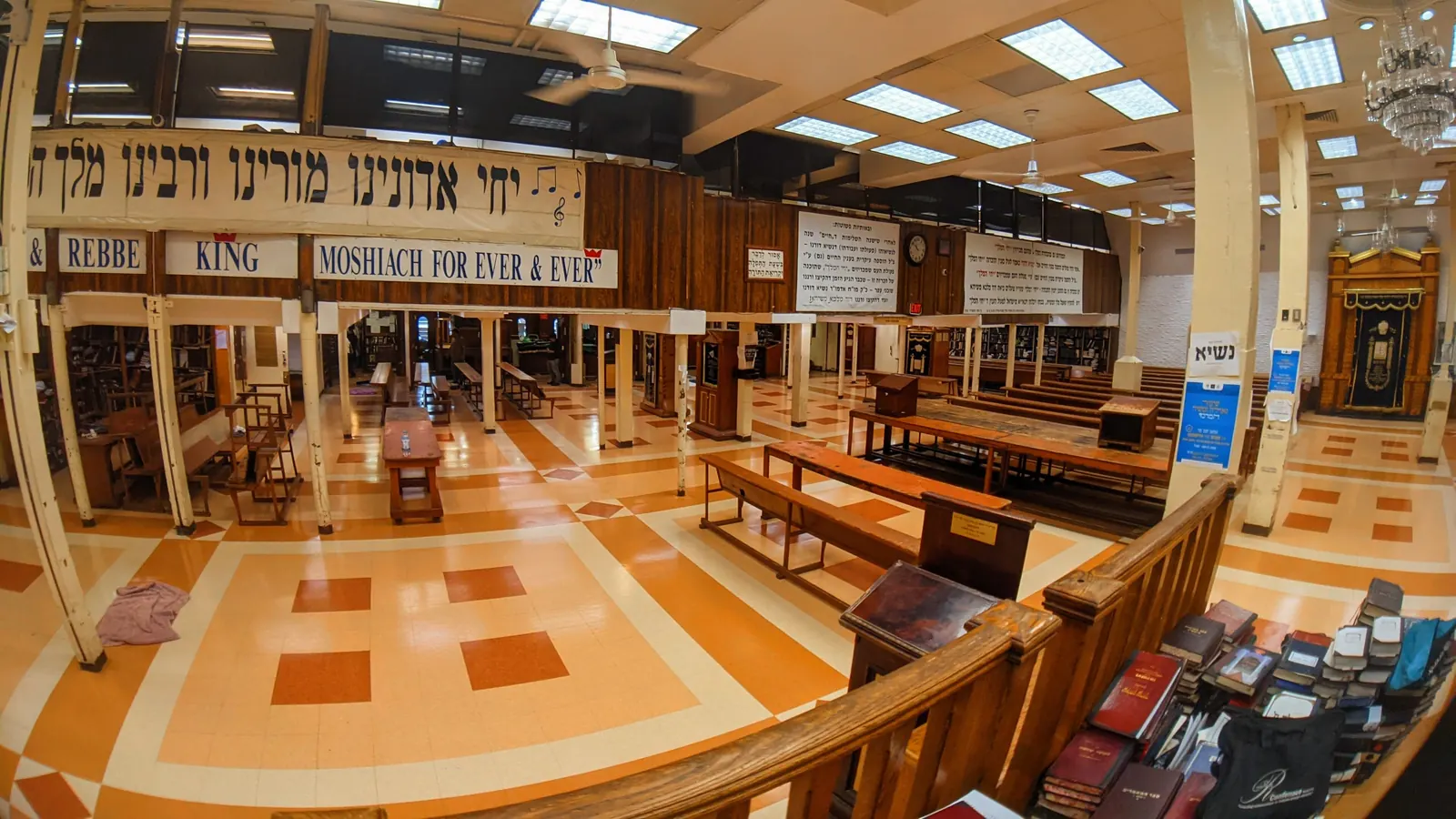 The empty main synagogue hall at 770 Eastern Parkway, Brooklyn, with a Yechi banner