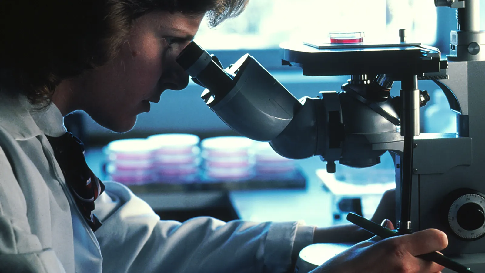 A scientist looking through a microscope in a laboratory