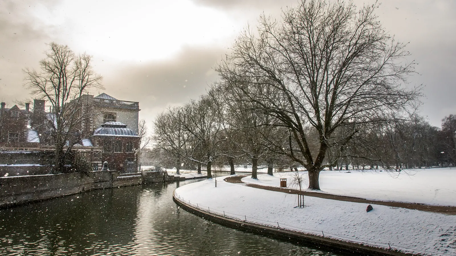The River Cam in Cambridge, England, with snow on the riverbank and bare trees