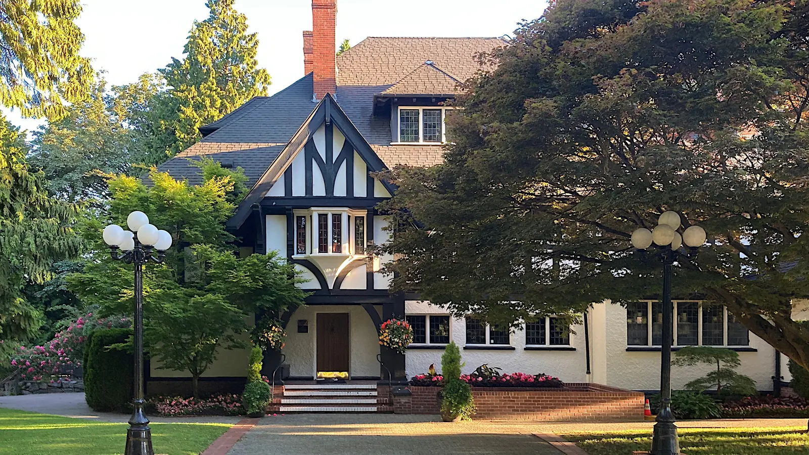A Tudor-style family house with a front garden and trees